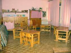  Una delle aule. Il colore rosa di pareti e tende e la presenza del legno abbracciano i bambini creando un ambiente accogliente